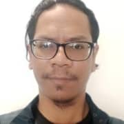 Headshot of a man wearing glasses and hair pulled back