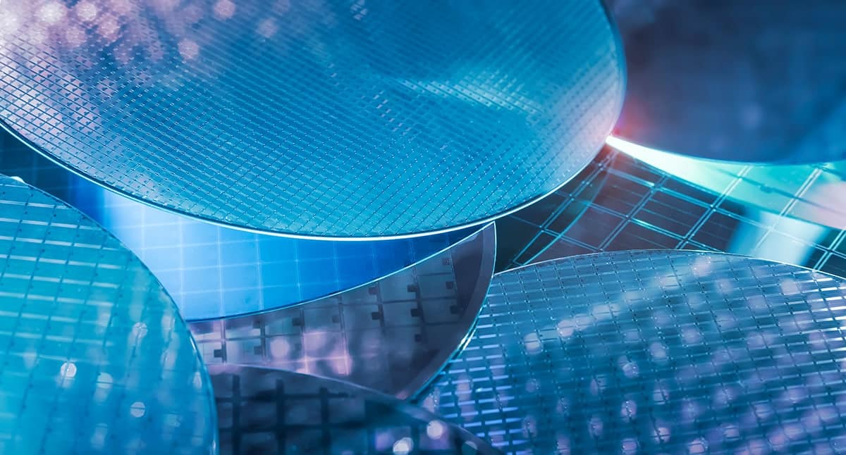 About eight semiconductor wafers scattered, making a collage with a blue color overlay